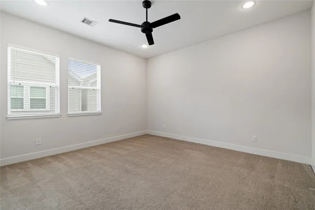 an empty room with a window and a fan
