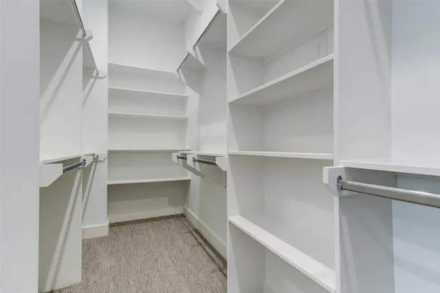 a view of walk in closet with empty racks