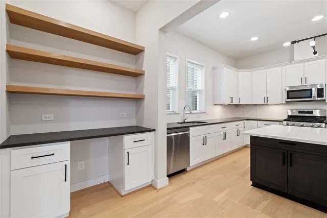 a kitchen with granite countertop white cabinets and white appliances