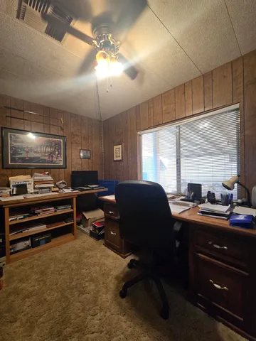 a view of a workspace with furniture and a window