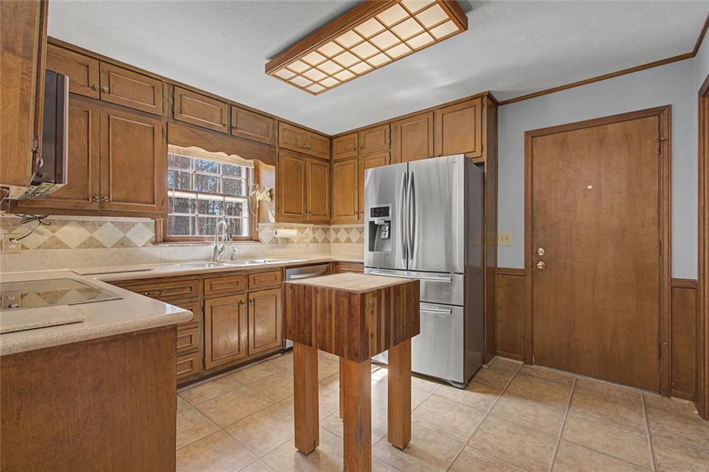 5877 Millstone Run Stone Mountain, GA 30087 - Photo 20 of 71 a kitchen with stainless steel appliances granite countertop a refrigerator and a sink