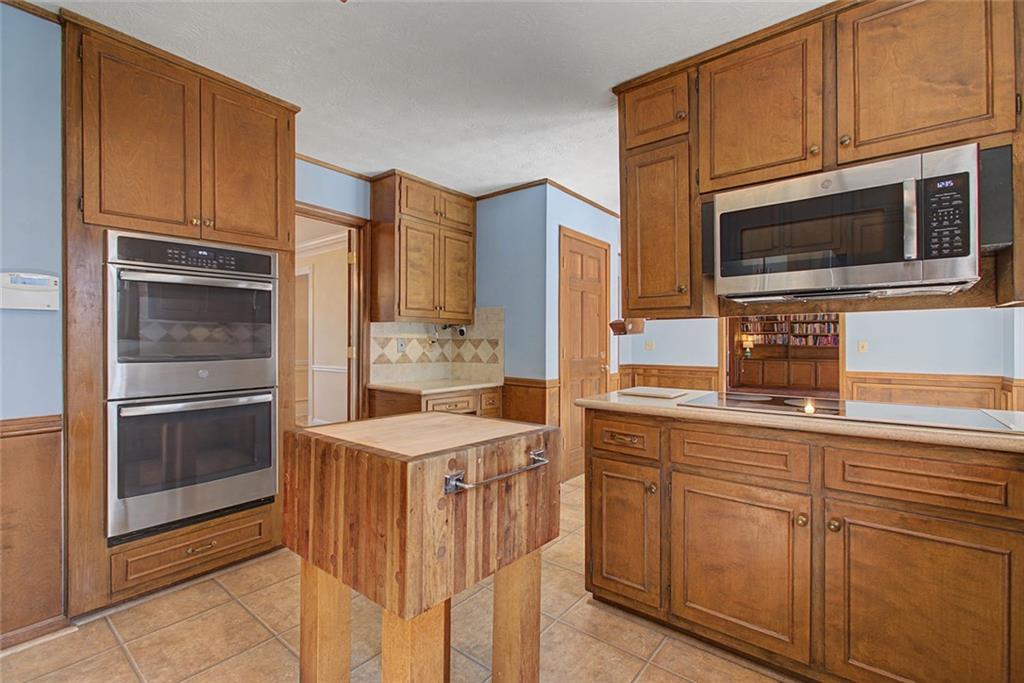 5877 Millstone Run Stone Mountain, GA 30087 - Photo 21 of 71 a kitchen with stainless steel appliances granite countertop a stove microwave and refrigerator