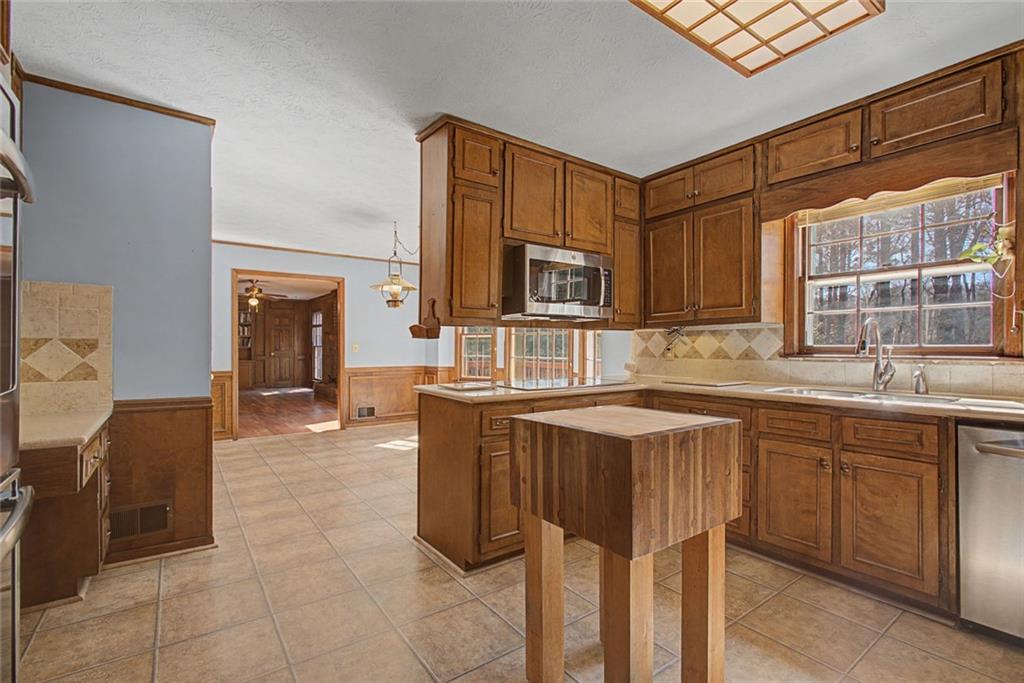 5877 Millstone Run Stone Mountain, GA 30087 - Photo 23 of 71 a spacious kitchen with stainless steel appliances granite countertop a sink and a refrigerator