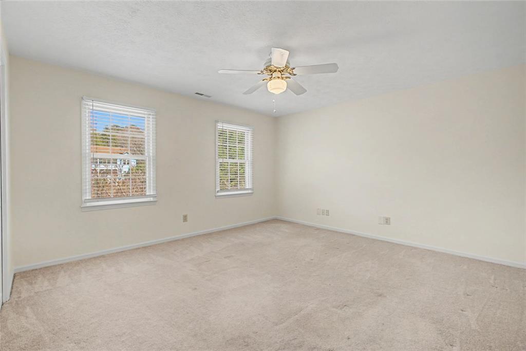 5877 Millstone Run Stone Mountain, GA 30087 - Photo 29 of 71 an empty room with windows and fan