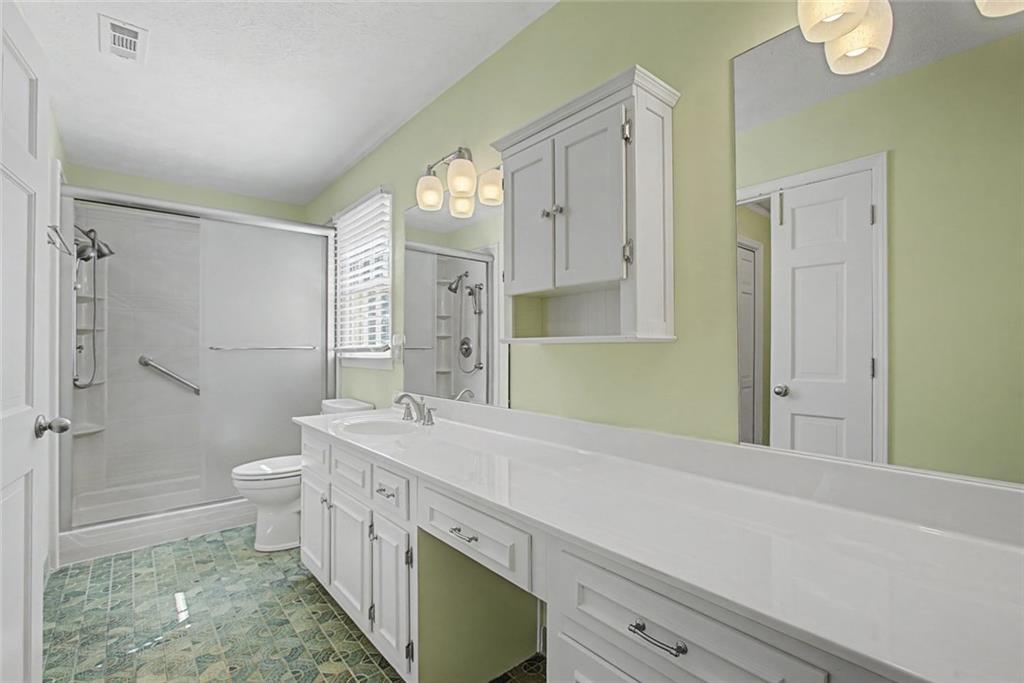 5877 Millstone Run Stone Mountain, GA 30087 - Photo 34 of 71 a bathroom with a sink a toilet and shower