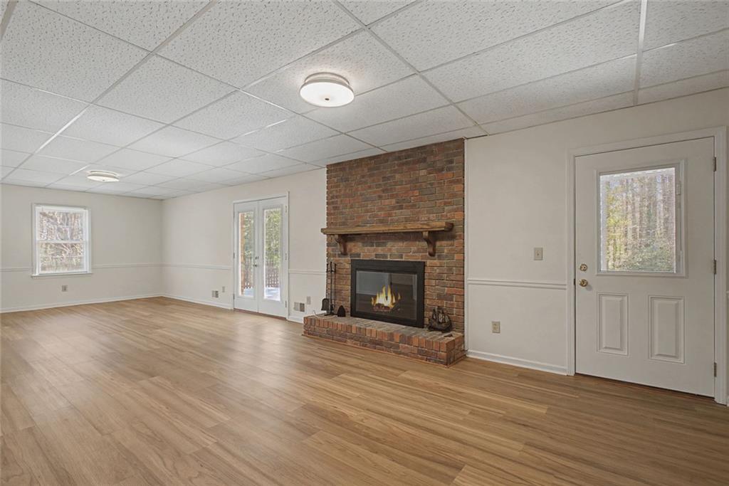 5877 Millstone Run Stone Mountain, GA 30087 - Photo 42 of 71 an empty room with wooden floor fireplace and windows