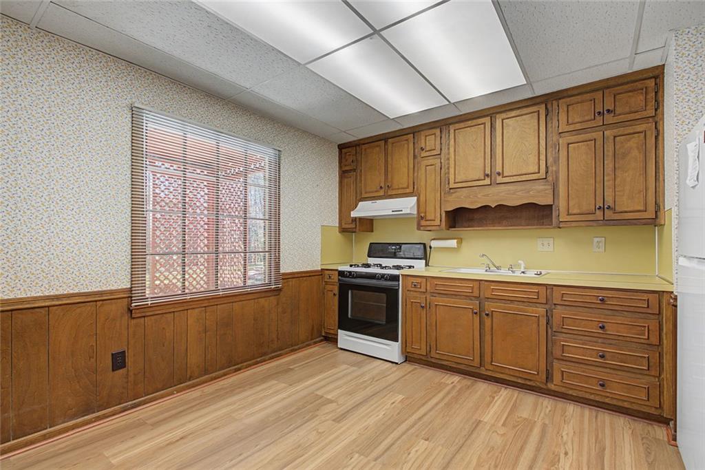 5877 Millstone Run Stone Mountain, GA 30087 - Photo 43 of 71 a kitchen with stainless steel appliances granite countertop a stove sink and cabinets