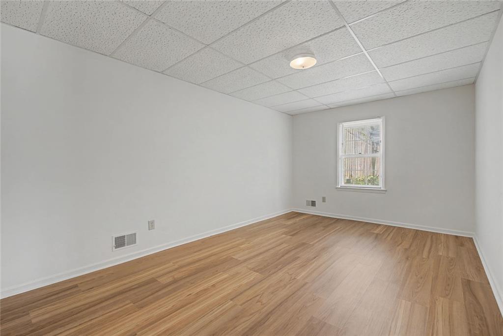 5877 Millstone Run Stone Mountain, GA 30087 - Photo 47 of 71 an empty room with wooden floor and windows