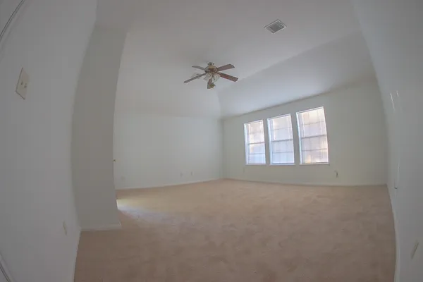 an empty room with a window and a ceiling fan