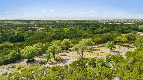 an aerial view of residential houses with outdoor space and trees