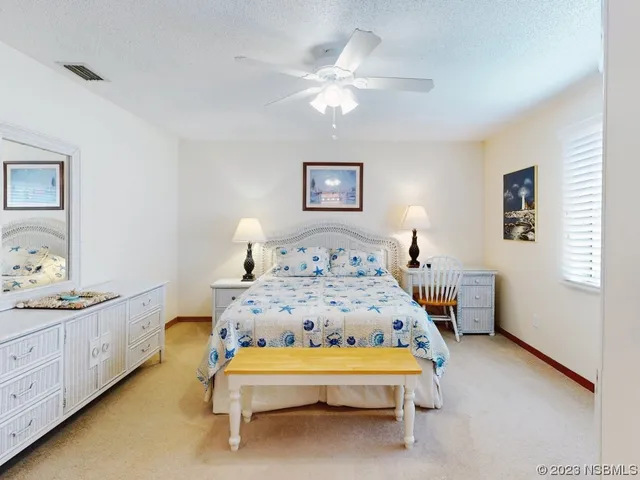 a spacious bedroom with a bed and a lamp