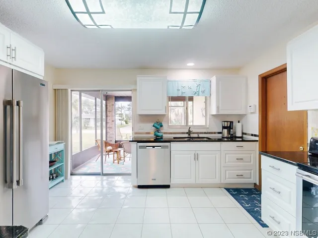 a kitchen with stainless steel appliances granite countertop a refrigerator and a stove top oven