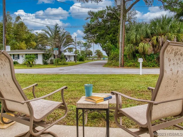 a view of small wooden house with a small yard and wooden fence