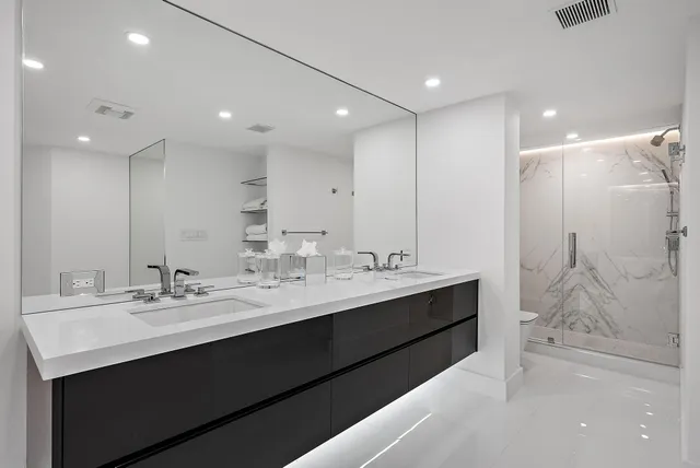 a bathroom with a double vanity sink mirror and shower