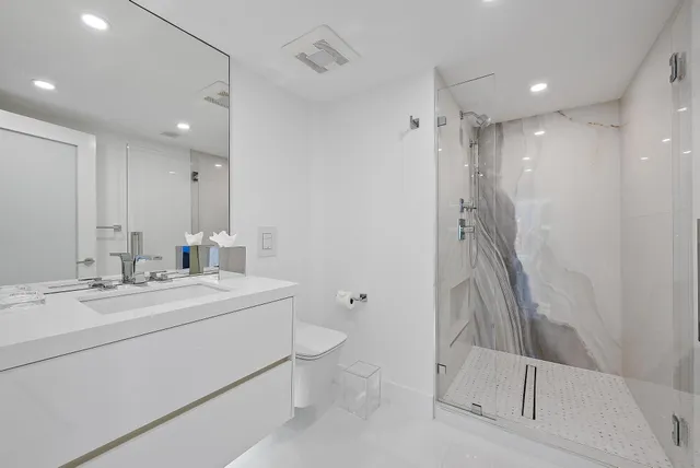 a bathroom with a double vanity sink mirror and toilet