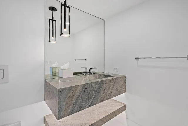 a bathroom with a granite countertop sink a mirror and vanity