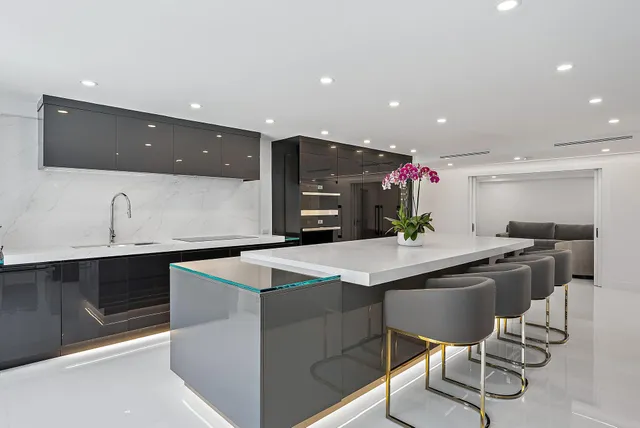 a kitchen with stainless steel appliances kitchen island granite countertop a sink and a refrigerator