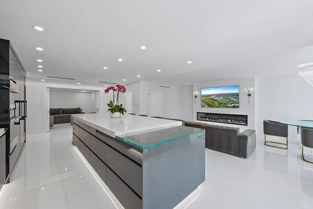 a kitchen with stainless steel appliances a stove a chimney a sink and a refrigerator