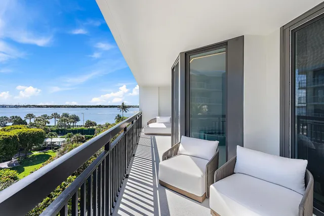 a balcony with wooden floor and outdoor seating