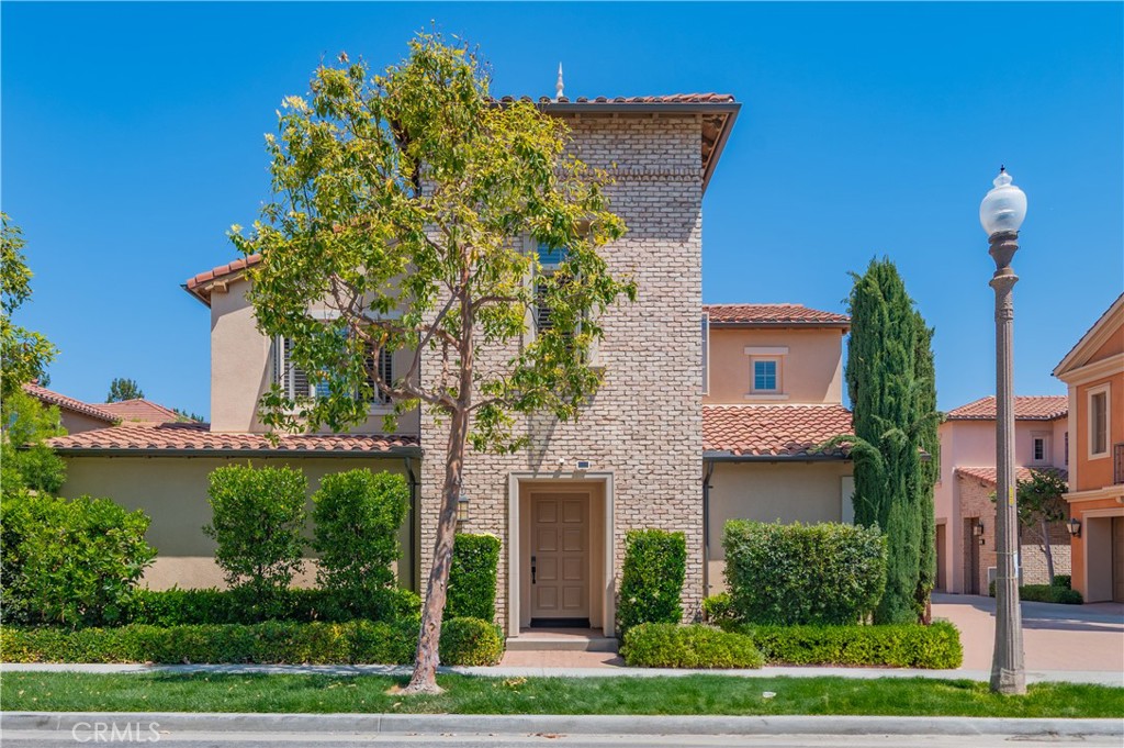 a front view of a house with a yard and potted plants