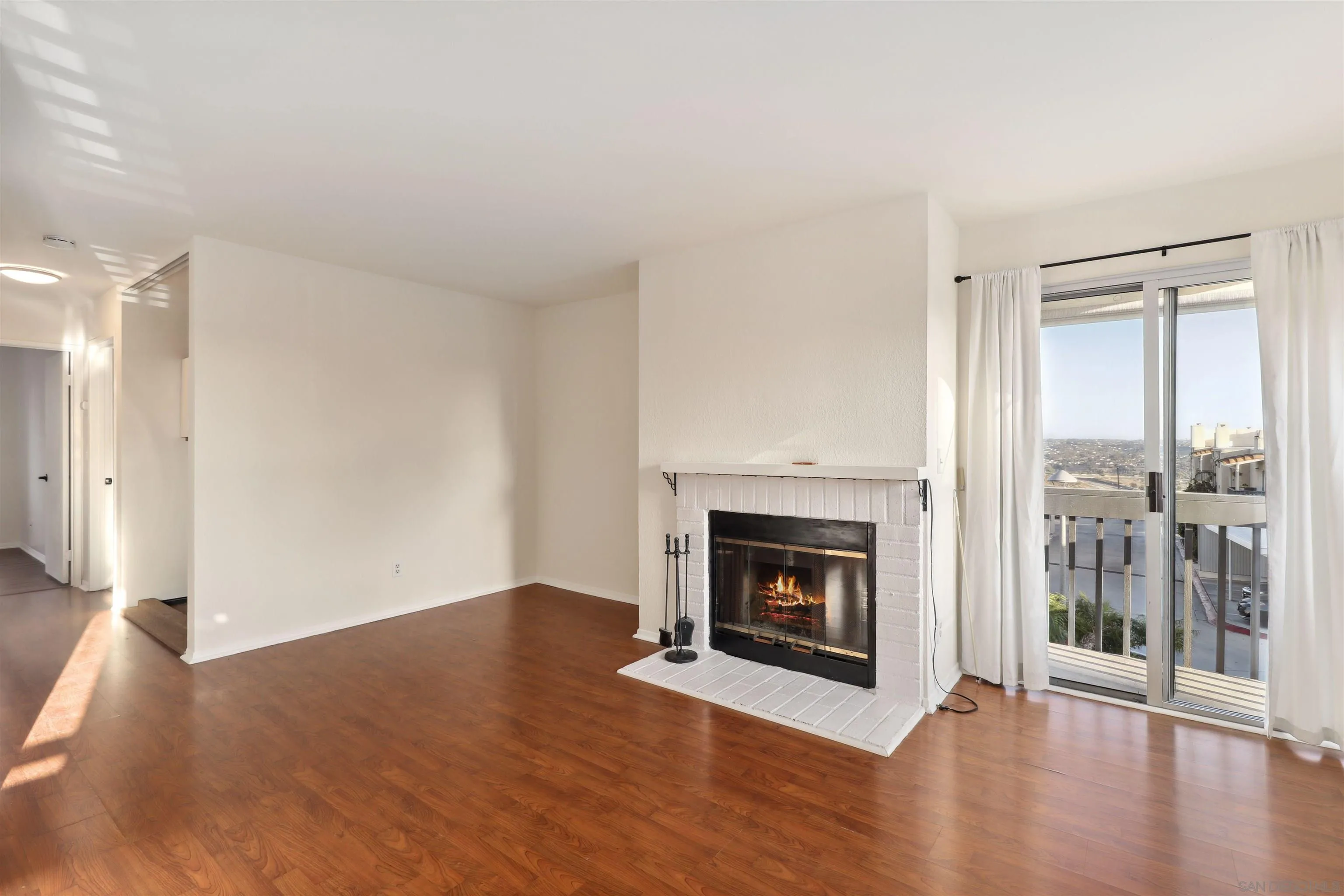 8475 Avenida Angulia, Unit 4 Spring Valley, CA 91977 - Photo 5 of 25 a view of an empty room with wooden floor fireplace and a window