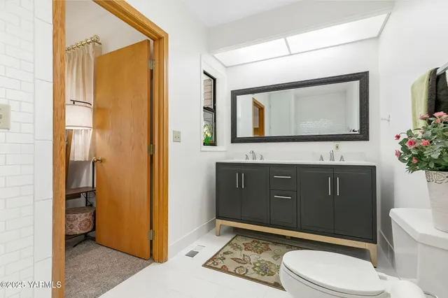 a bathroom with a toilet a sink and mirror