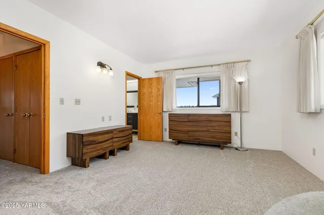 a view of a hallway with wooden floor and a large mirror