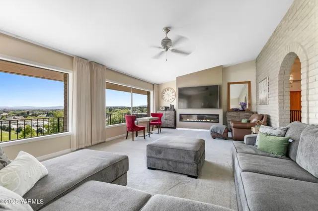 a living room with furniture and a floor to ceiling window