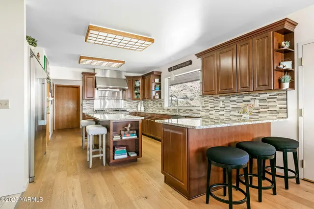 a kitchen with stainless steel appliances granite countertop a sink a stove and a refrigerator