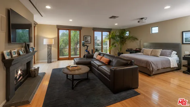 a large bedroom with a large bed and a flat tv screen