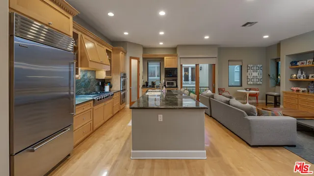 a kitchen with stainless steel appliances granite countertop a sink and a refrigerator