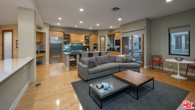 a living room with furniture and a view of kitchen