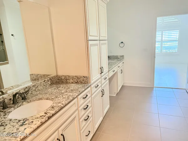 a bathroom with a granite countertop sink a mirror and a bathtub