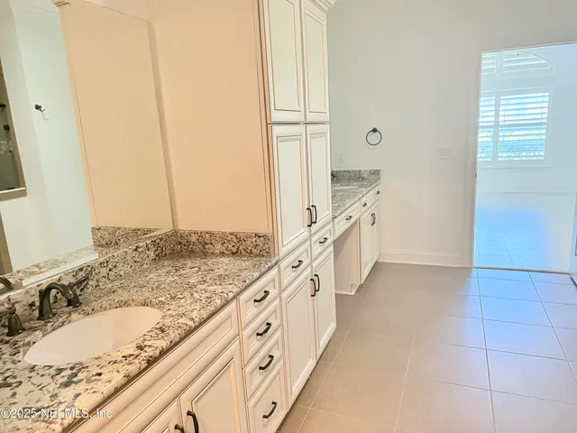 a bathroom with a granite countertop sink a mirror and a bathtub