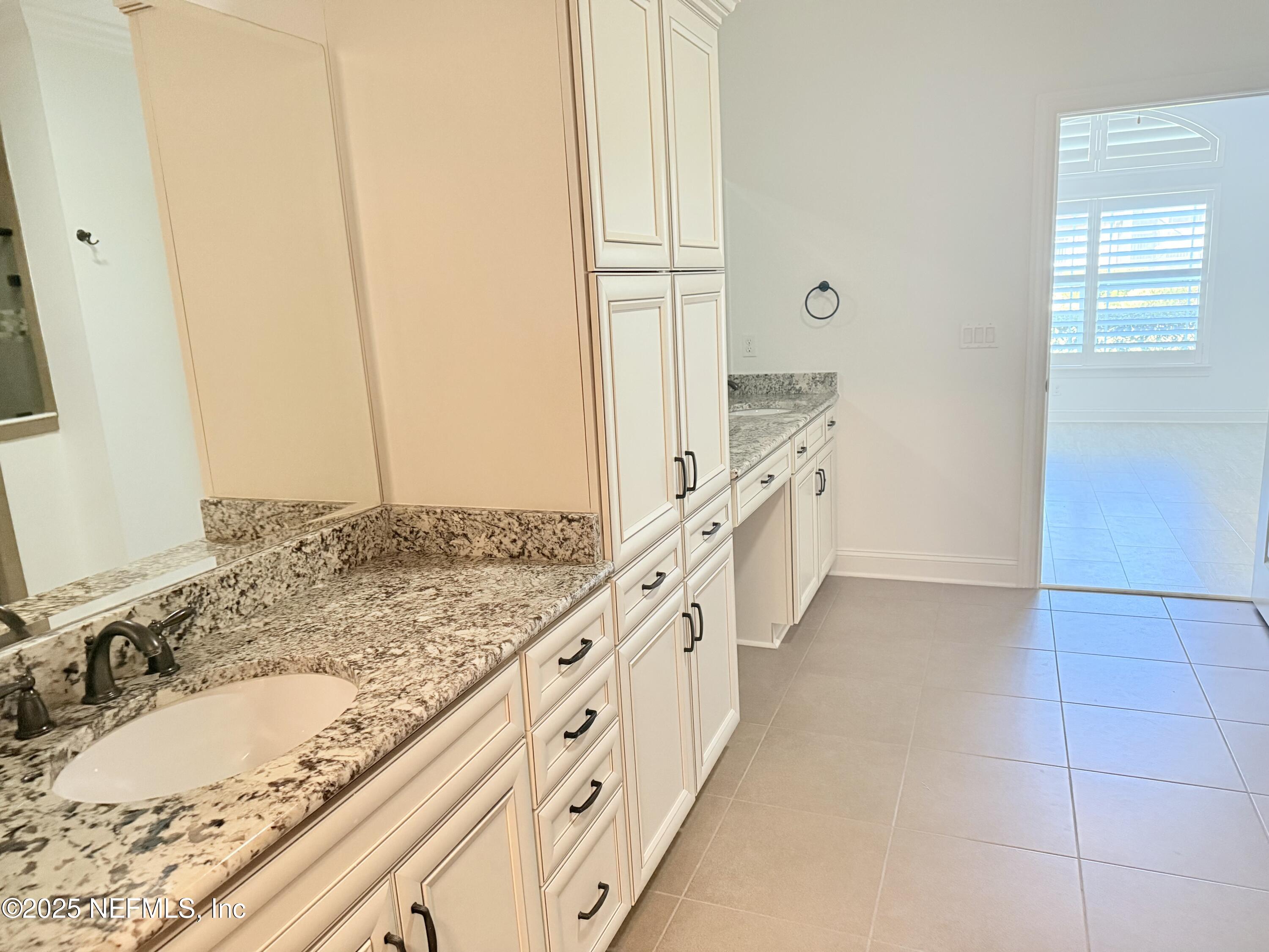 44 Ocale Court St. Augustine, FL 32084 - Photo 22 of 30 a bathroom with a granite countertop sink a mirror and a bathtub