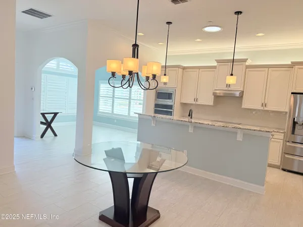 a kitchen with stainless steel appliances granite countertop a sink a counter space and a view of living room