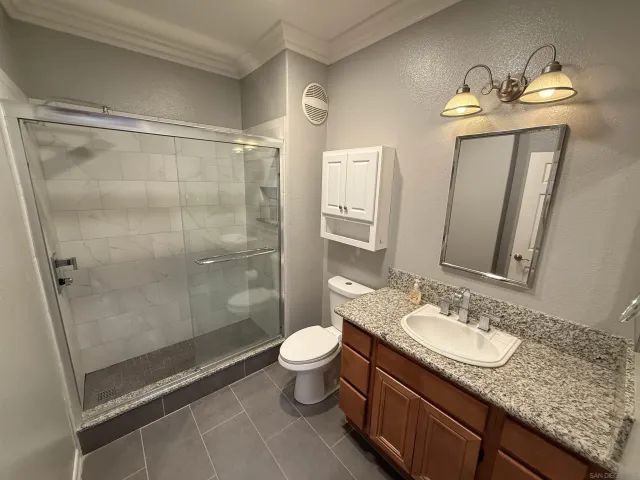 a bathroom with a granite countertop sink toilet and shower
