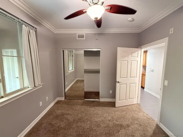 a view of empty room with ceiling fan and window