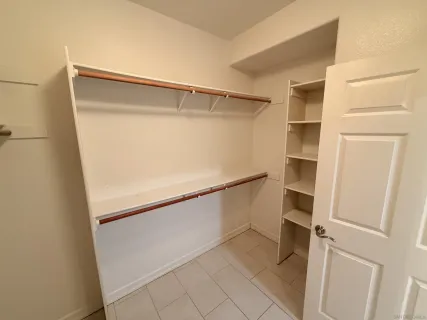 a view of walk in closet with empty racks