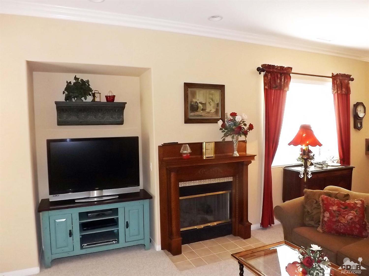 80540 Knightswood Road Indio, CA 92201 - Photo 12 of 34 a living room with furniture a flat screen tv and a fireplace