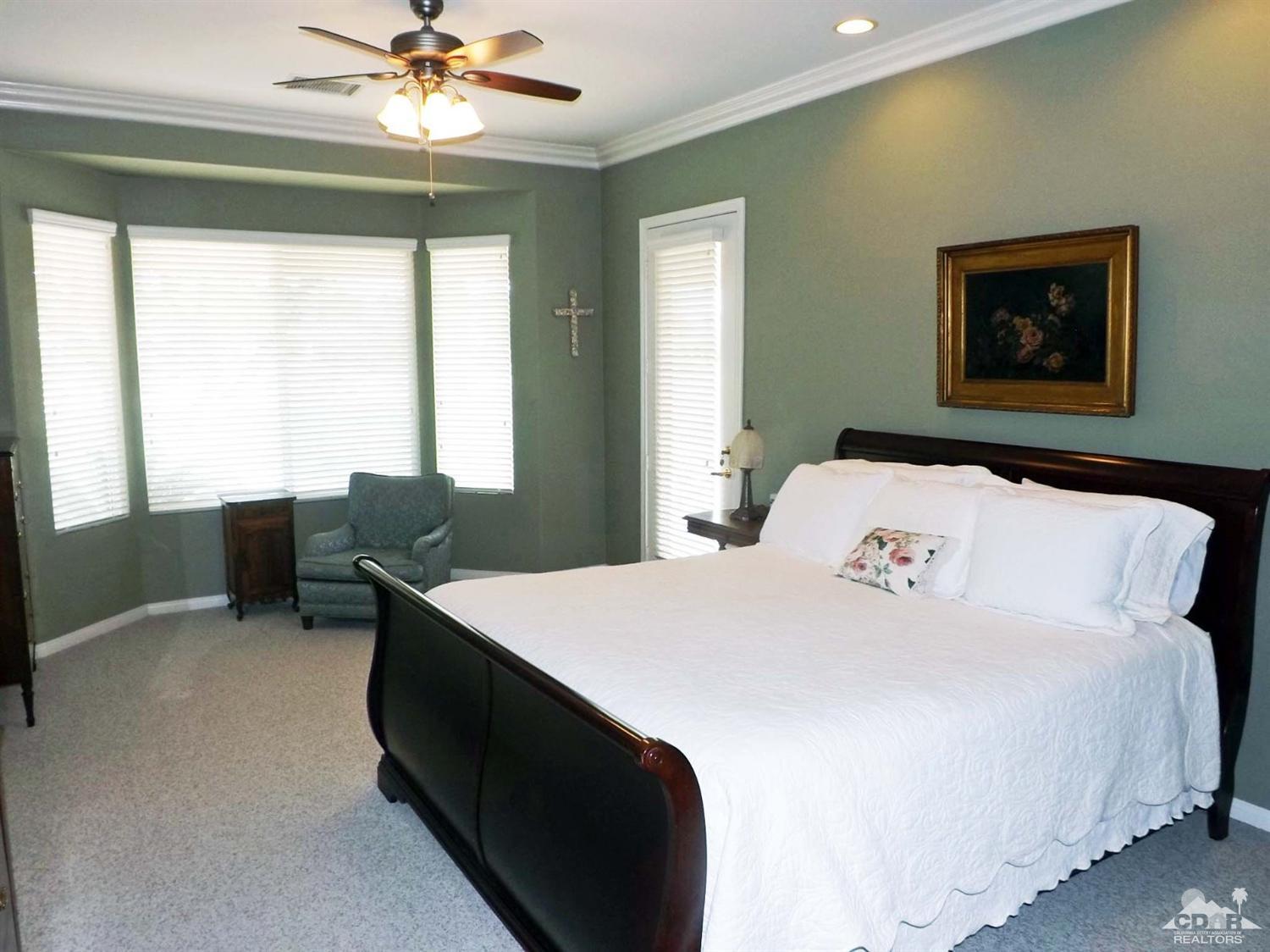 80540 Knightswood Road Indio, CA 92201 - Photo 13 of 34 a bedroom with a bed and a chandelier
