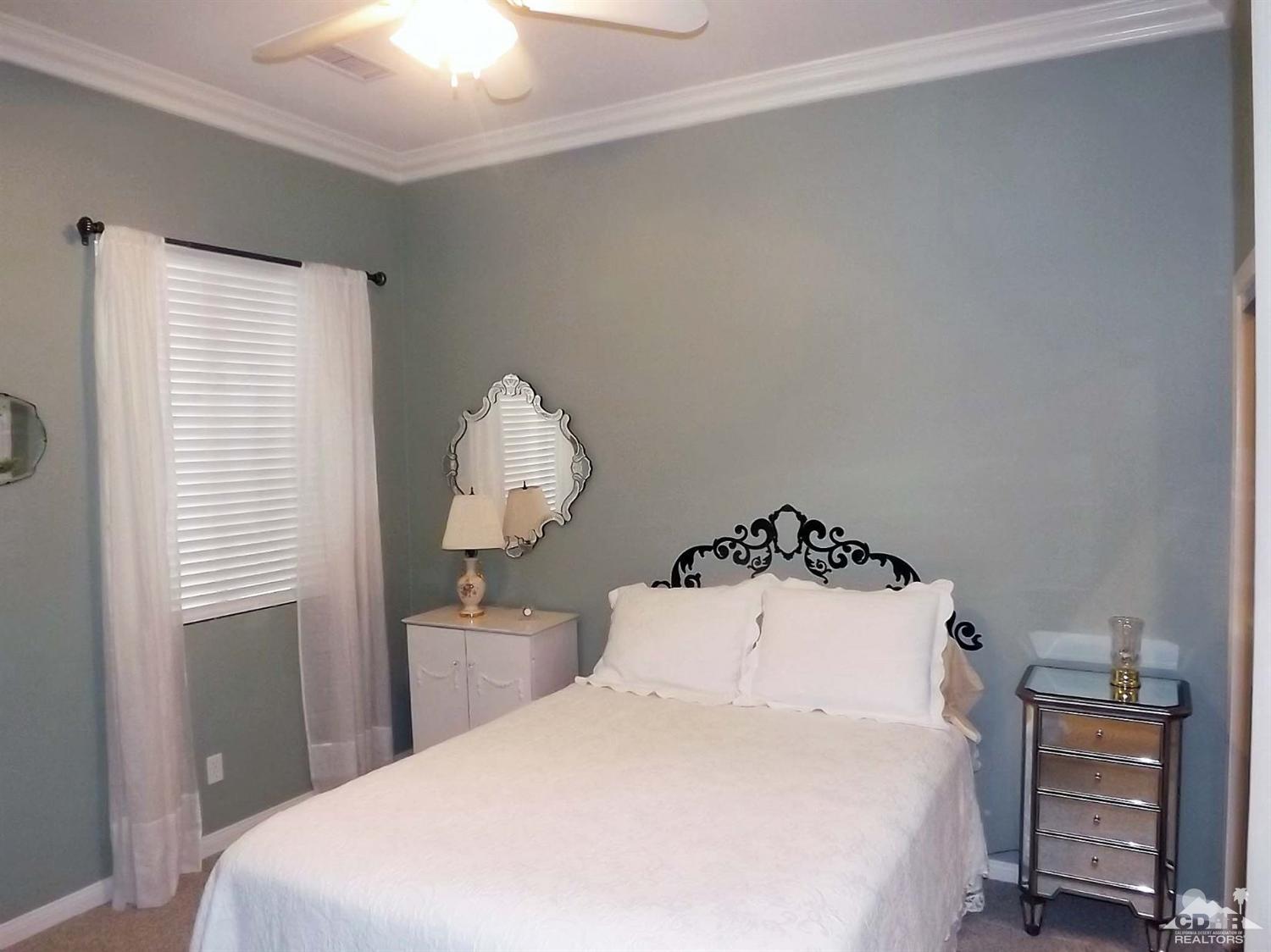 80540 Knightswood Road Indio, CA 92201 - Photo 17 of 34 a bedroom with a bed and a chandelier
