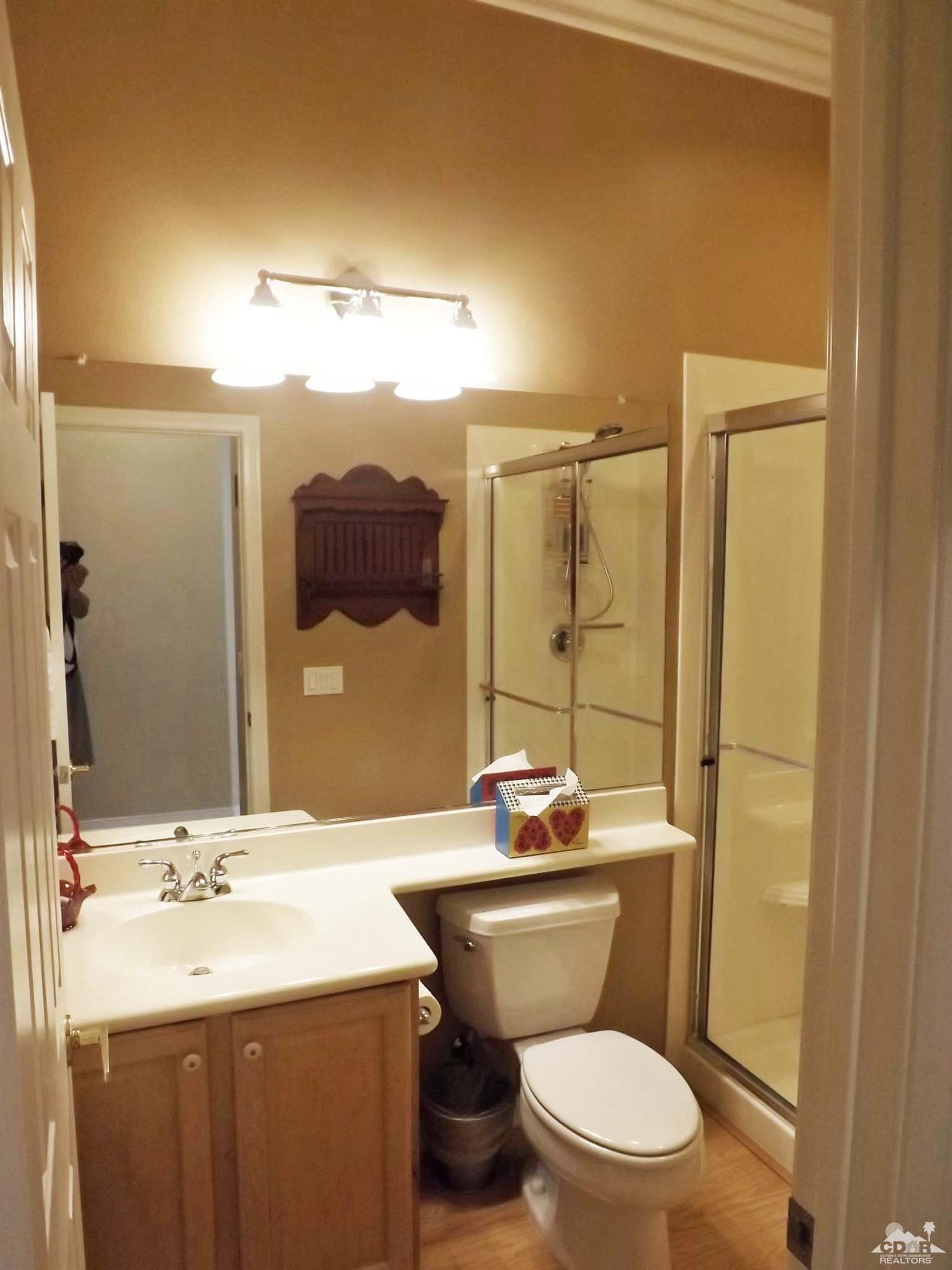 80540 Knightswood Road Indio, CA 92201 - Photo 18 of 34 a bathroom with a sink a toilet a mirror and shower