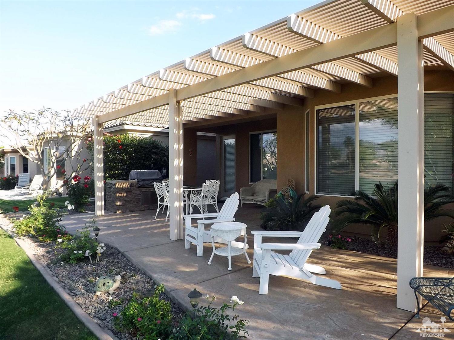 80540 Knightswood Road Indio, CA 92201 - Photo 27 of 34 a view of a patio with table and chairs potted plants and floor to ceiling window