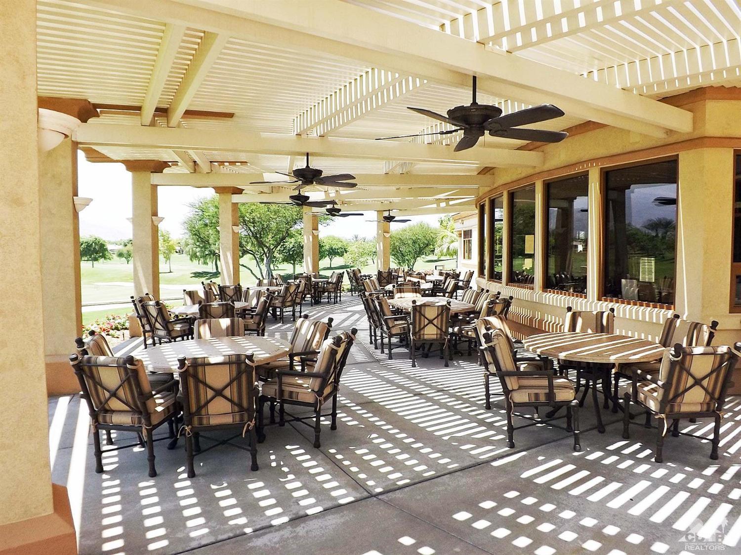 80540 Knightswood Road Indio, CA 92201 - Photo 29 of 34 a outdoor space with lots of tables a large window and chairs