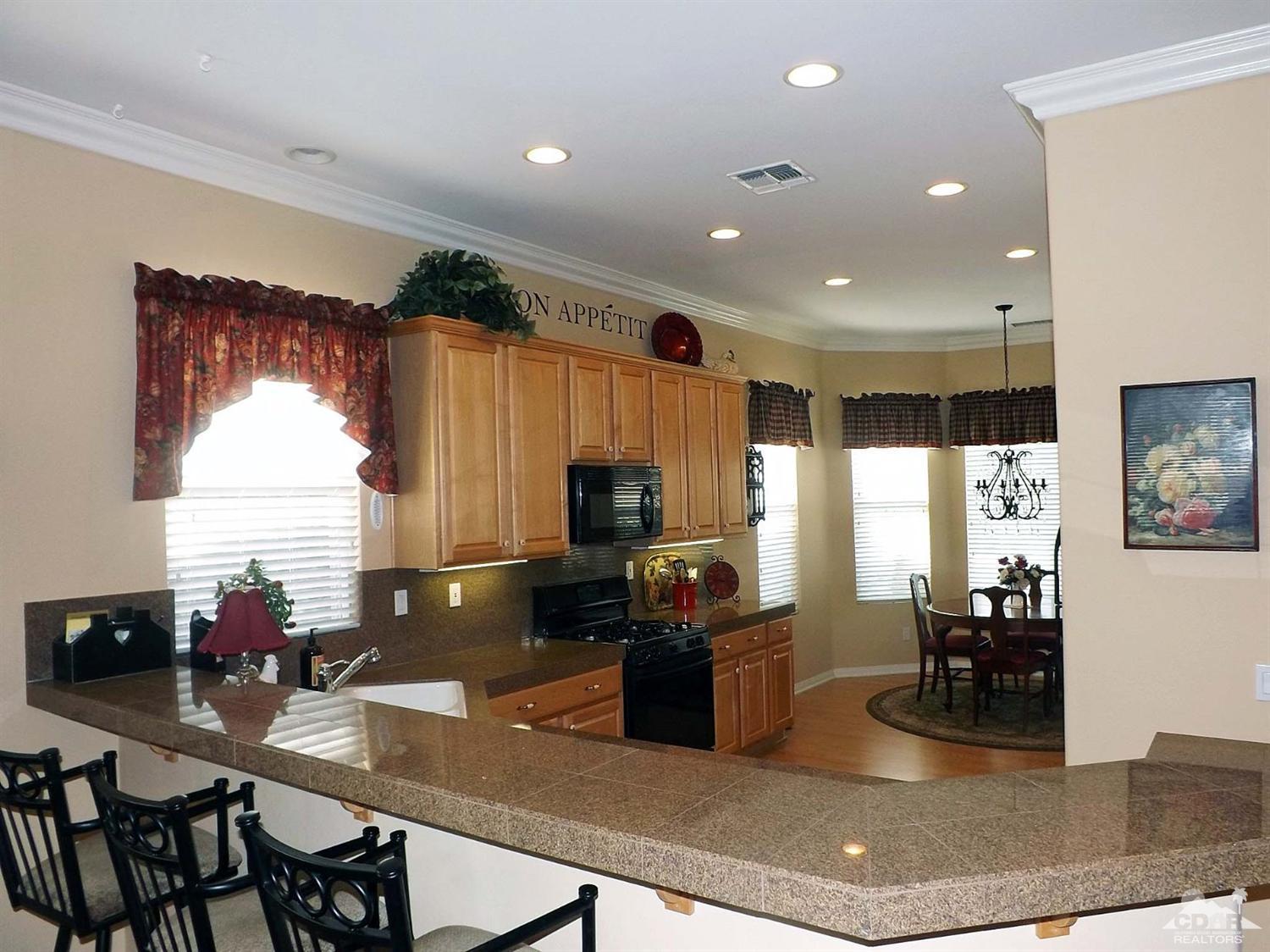 80540 Knightswood Road Indio, CA 92201 - Photo 6 of 34 a kitchen with sink a refrigerator and chairs
