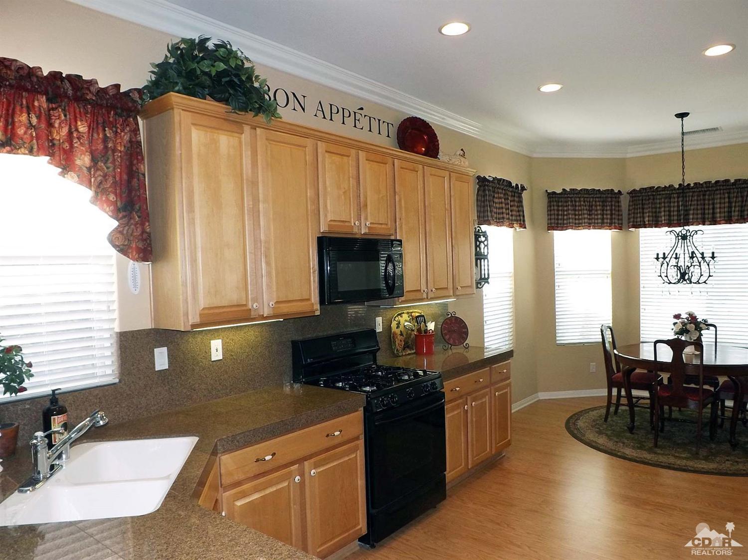 80540 Knightswood Road Indio, CA 92201 - Photo 7 of 34 a kitchen with kitchen island granite countertop a sink counter top space and a window