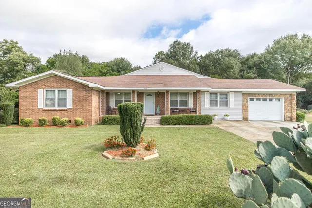 a view of a house with a yard and sitting area