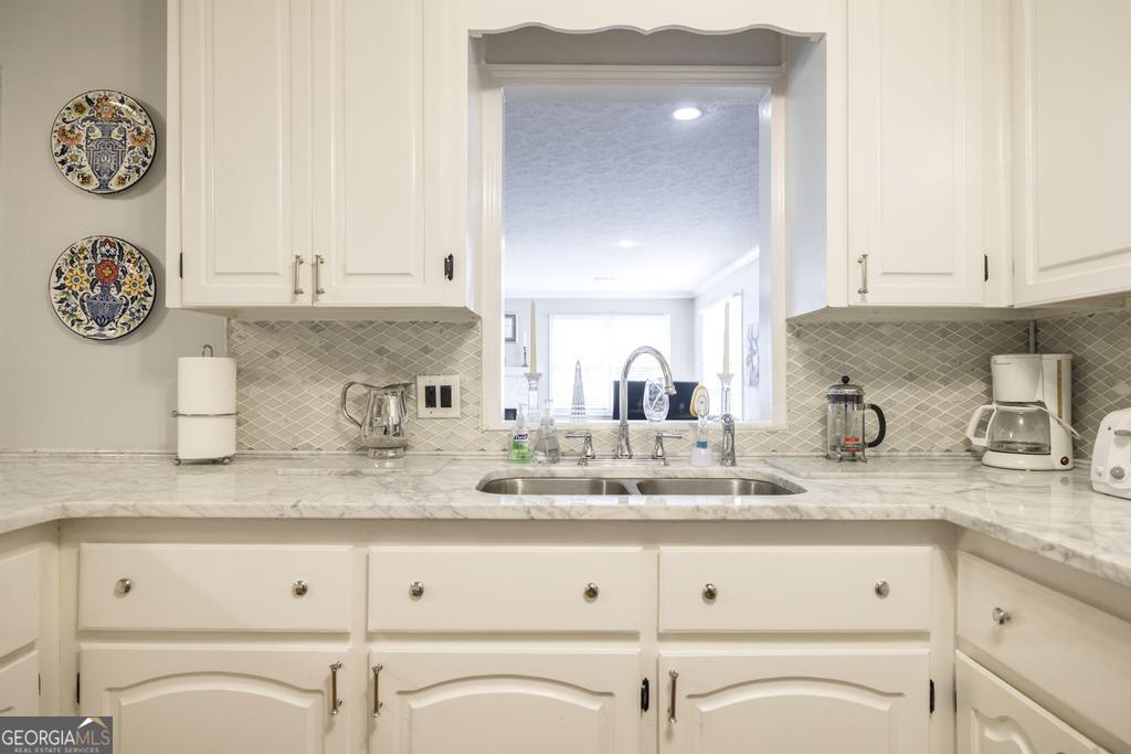 209 Spillers Street Fort Valley, GA 31030 - Photo 13 of 36 a bathroom with granite countertop white cabinets and a sink