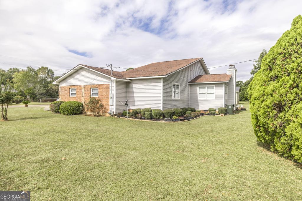 209 Spillers Street Fort Valley, GA 31030 - Photo 33 of 36 a front view of a house with a garden and trees